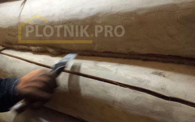 Процесс конопатки сруба